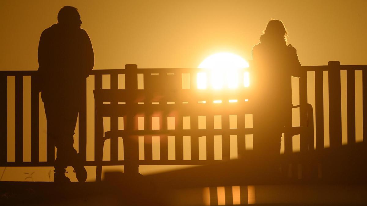Dos personas observan el sol