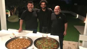 Salah, con Jaume Tárrega (a su izquierda) y David Martí, que cocinaron la paella y el ’arròs de senyoret’ que cenó el delantero del Liverpool en Benicàssim.