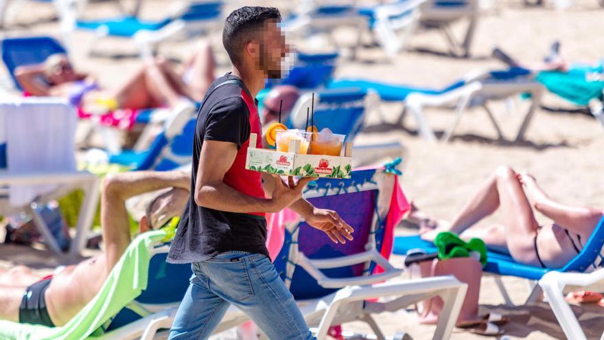 Uno de los «mojiteros» con una bandeja de bebida en una de las playas de Benidorm. DAVID REVENGA