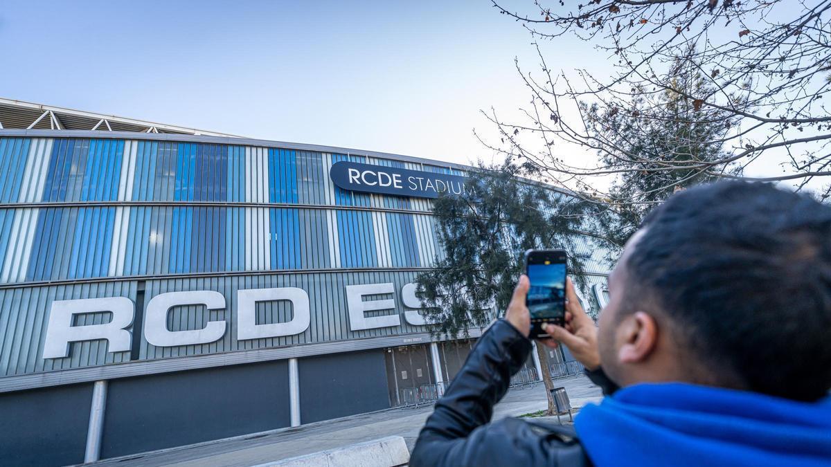 Un vecino de Cornellà toma una foto de la fachada del estadio del Espanyol con su móvil.