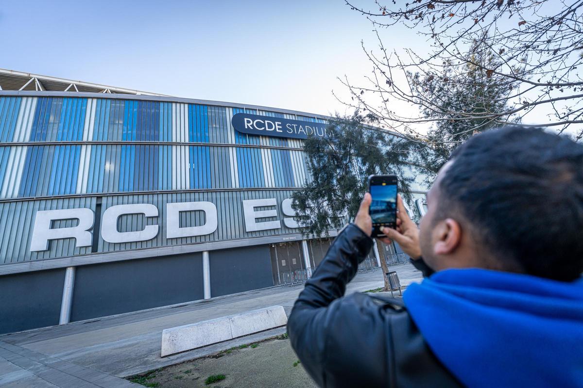 Un vecino de Cornellà toma una foto de la fachada del estadio del Espanyol con su móvil.