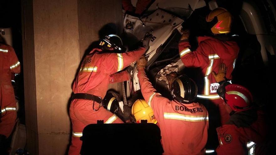 Los bomberos excarcelan a los dos ocupantes del camión.