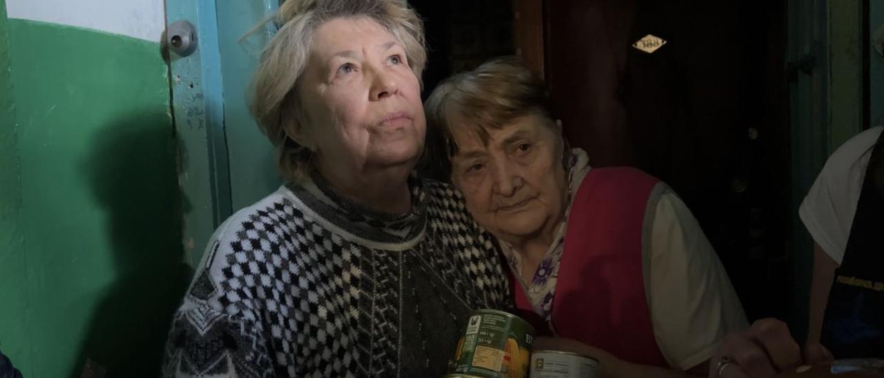 Dos mujeres reciben ayuda de voluntarios en Járkov (Ucrania).