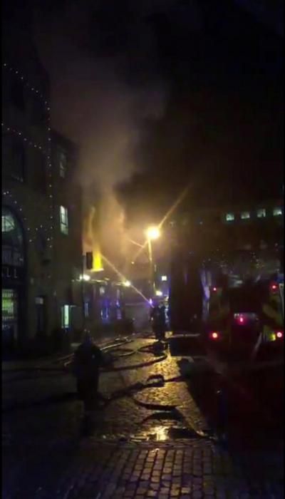 Firefighters spray water onto a fire at Camden ...