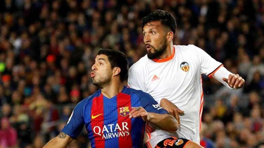 Ezequiel Garay defiende a Luis Suárez en el Camp Nou.