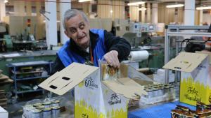 Un trabajador en riesgo de exclusión sociolaboral de la Fundación Juan XXIII prepara una cesta de Navidad.