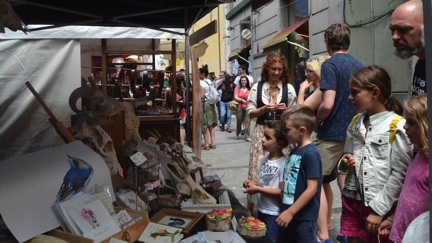 Una familia curiosea en uno de los puestos próximos a la calle Mayor de Llanes, ayer.