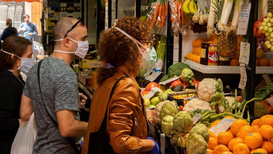 Clientes protegidos con mascarillas haciendo compras en Sevilla.