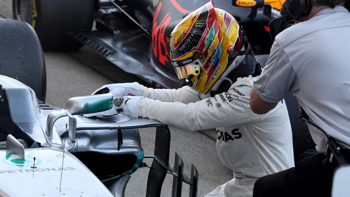 Hamilton, arrodillado en frente de su coche