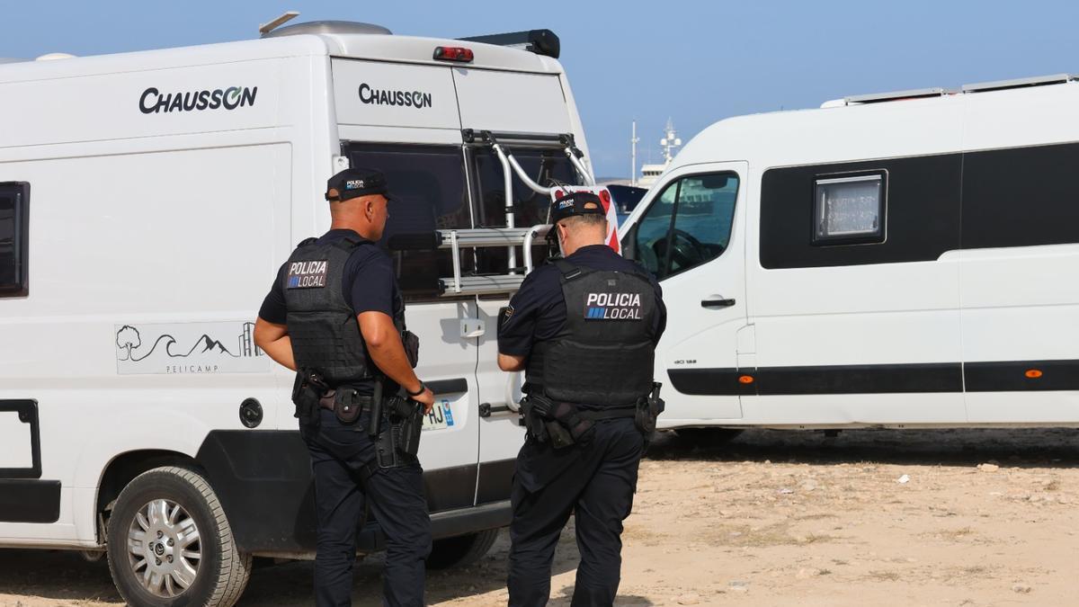 Dos Polícias Locales en una inspección de varias autocaravanas.