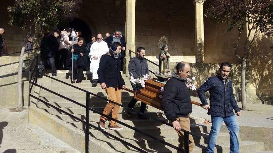 Los jóvenes y los vecinos de Cuelgamures acompañan a la figura de San Antón durante la procesión.