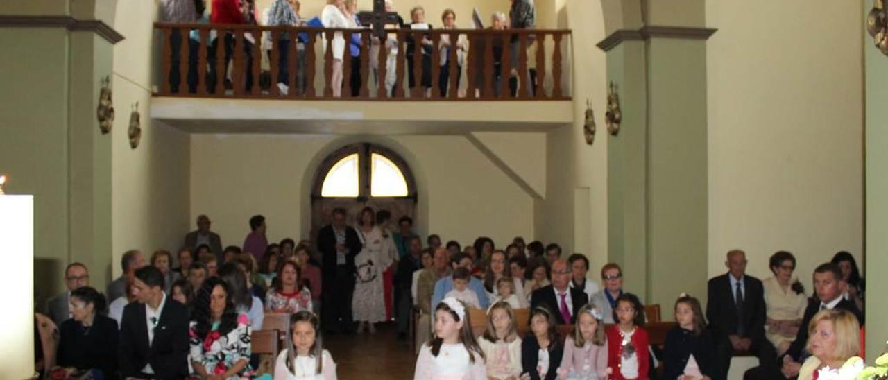 Asistentes ayer a la misa en la iglesia de Albandi, con las dos niñas que recibieron la primera comunión en primer término.