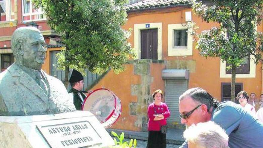 Vecinos del barrio de Cimadevilla ponen flores ante el busto de Arturo Arias. Arriba, detalle de la imagen.