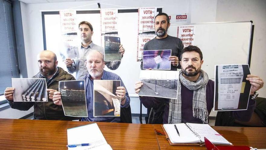 Miembros del comité de empresa de la fábrica coruñesa de Alcoa posan, ayer, con las fotos del material almacenado en el puerto de Vigo.