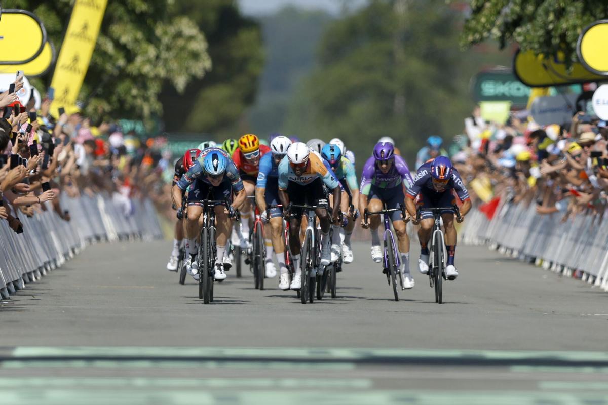 El ciclista belga Tim Merlier (izq.) cruza la línea de meta por delante del ciclista eritreo Biniam Girmay .