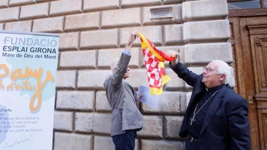 Eduard Berloso i Francesc Pardo, retirant la bandera de la ciutat de Girona per ensenyar la placa.