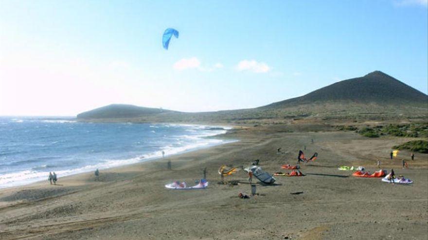 Varias personas practican deporte en la playa.