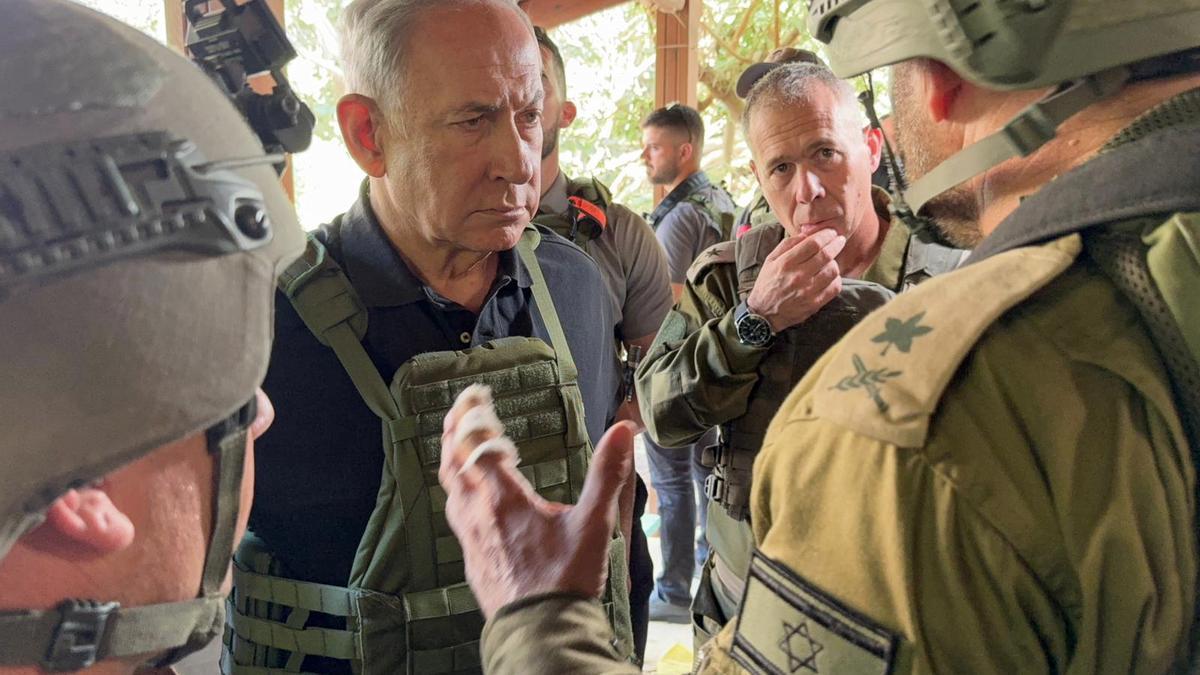 El primer ministro israelí, Binyamín Netanyahu, habla con soldados durante su visita al kibutz Beeri, este sábado.