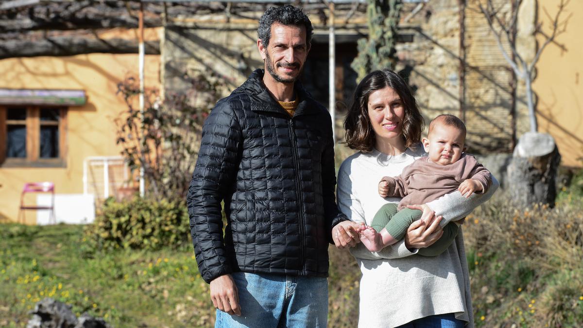 Eric Méndez y Alba Cervera, con su hijo Leo en brazos, frente a su casa.