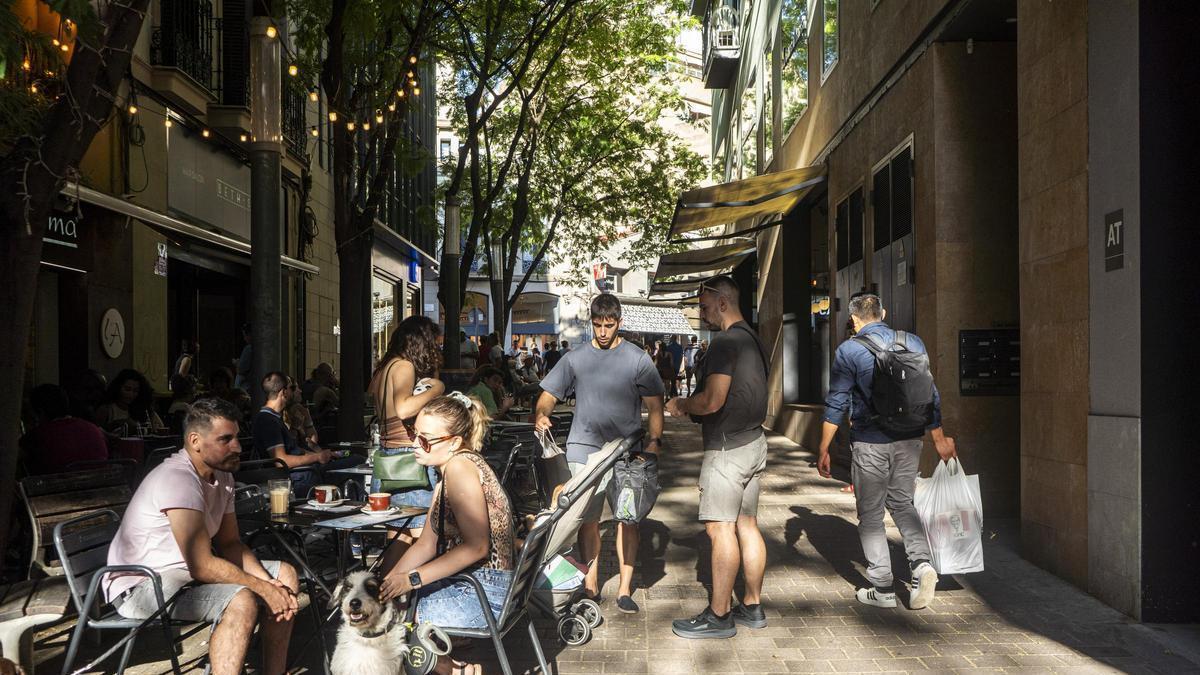 Gent en una terrassa de bar al centre de Manresa en un dia de sol i calor