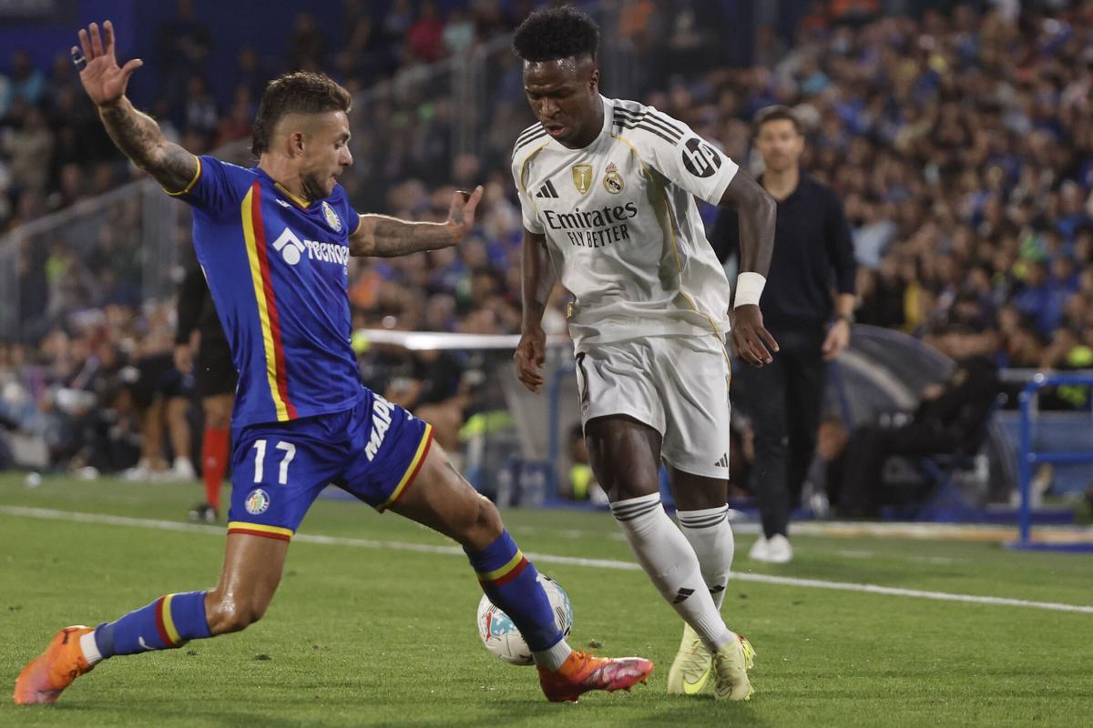 El delantero brasileño del Real Madrid, Vinicius Junior (d), intenta superar al defensa del Getafe, Kiko Femenía.