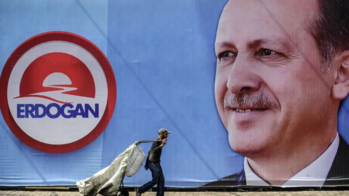 Un viandante pasa ante un cartel electoral de Erdogan en Estambul.