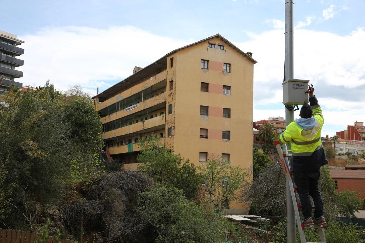 Un operario municipal instala una cámara de seguridad en las inmediaciones de 'El Barco', el edificio de Esplugues desalojado por riesgo de derrumbe