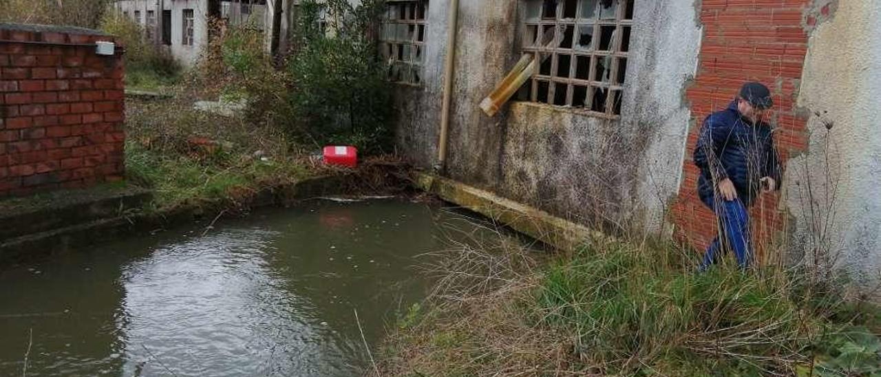 Miguel Ángel Villaverde, junto al río Texón, que pasa por debajo de un edificio en Posada.