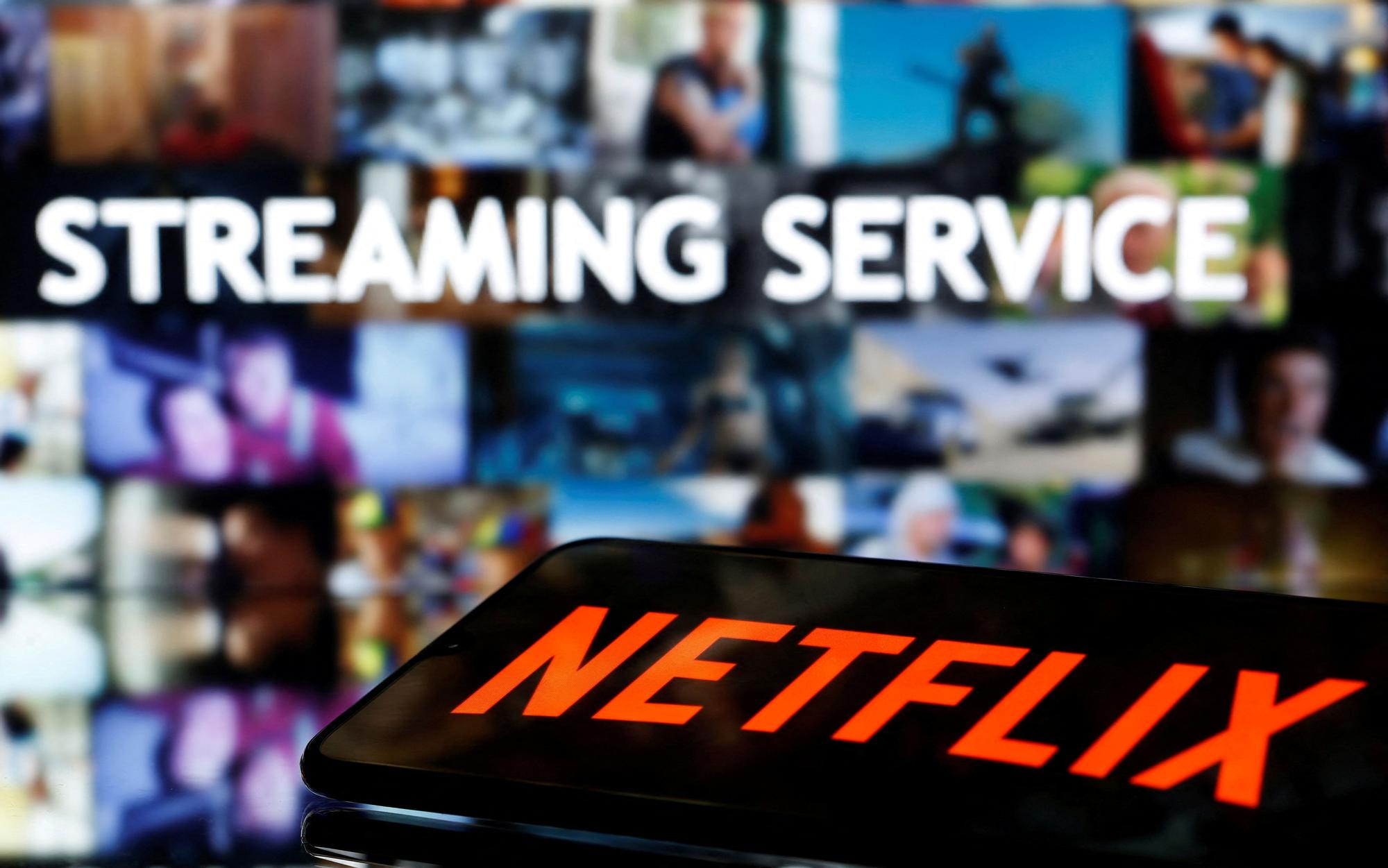 FILE PHOTO: A smartphone with the Netflix logo lies in front of displayed &quot;Streaming service&quot; words in this illustration