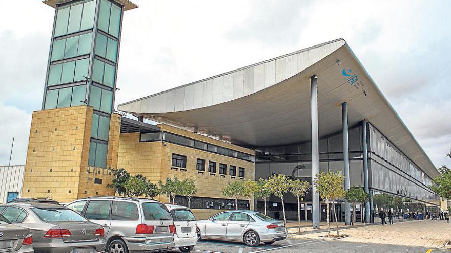 La fachada principal de la Institución Ferial Alicantina (IFA), con varios coches aparcados en el exterior.