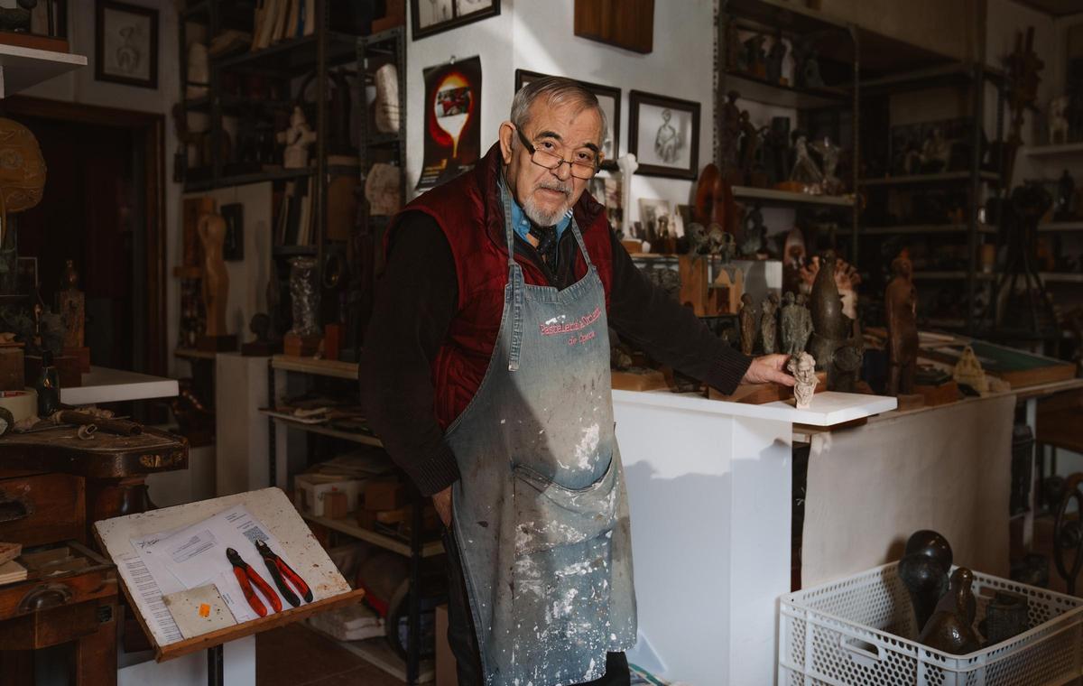 El escultor Jose Luis Fernández, en su estudio de Vallecas, posa con un 'cabezón' de Goya en miniatura.