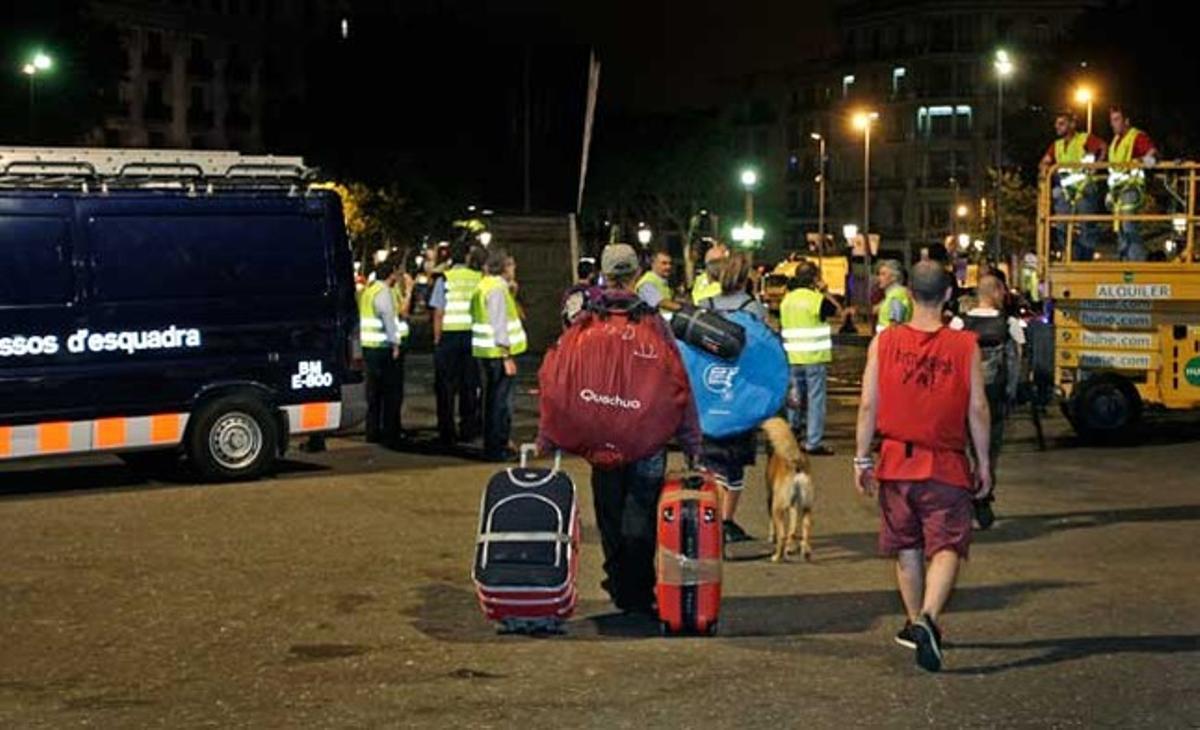 Treballadors del servei de neteja desmunten la barraca de la comissió anticrisi dels indignats.