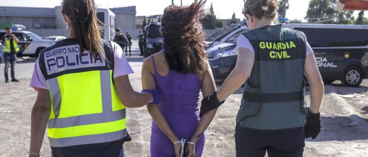 Una policía y una guardia civil llevan a una joven detenida. | B.RAMON