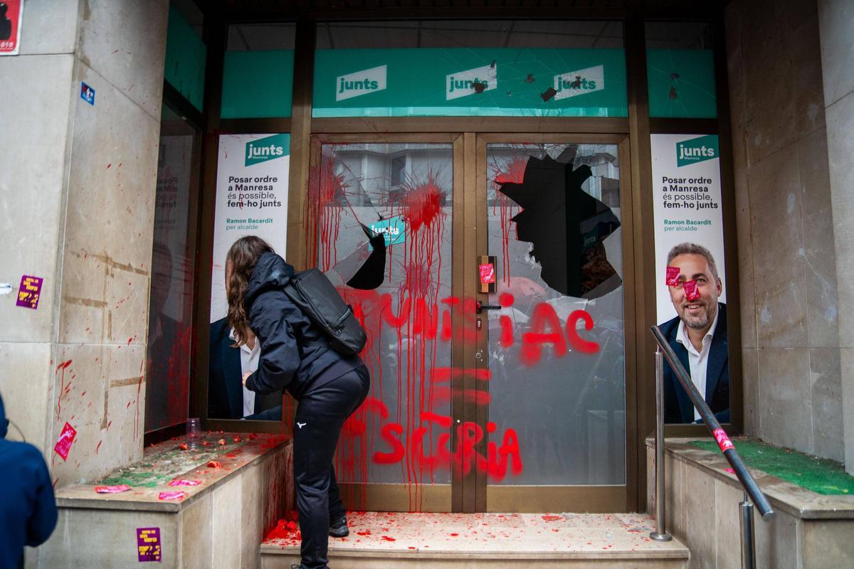 L'entrada al local de Junts amb pintades i els vidres trencats