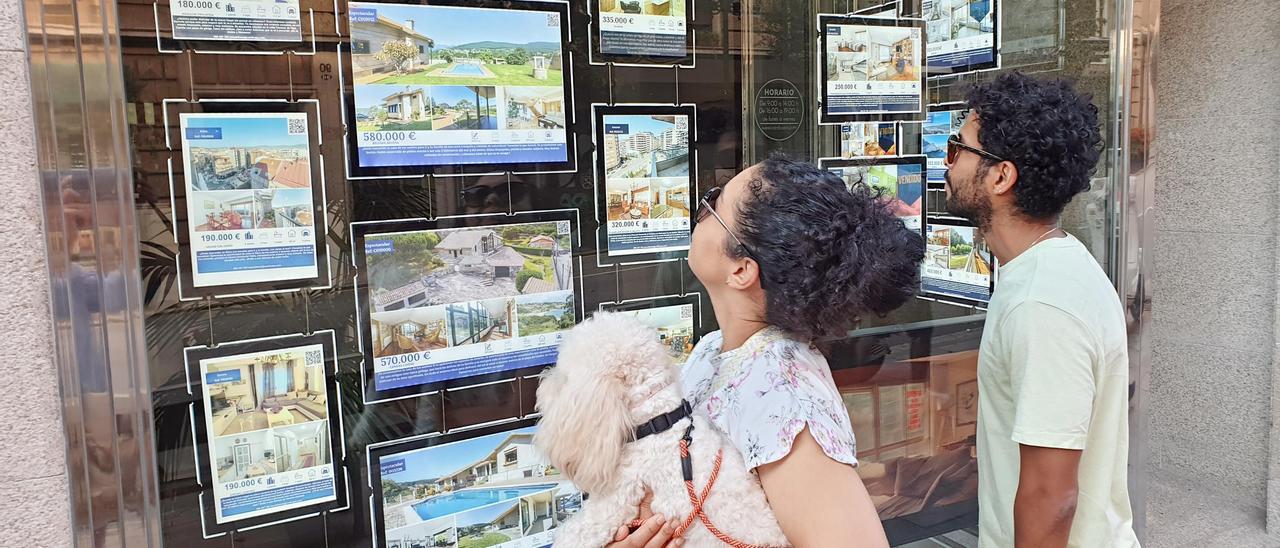 Una pareja consulta los precios de la vivienda en una inmobiliaria.