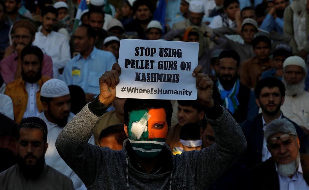 Un partidario del partido político y religioso Jamaat-e-Islami, con su rostro pintado con los colores de la bandera de Cachemira, sostiene un cartel mientras participa en un mitin para conmemorar el Día de la Solidaridad con Cachemira, en Karachi (Pakistán).