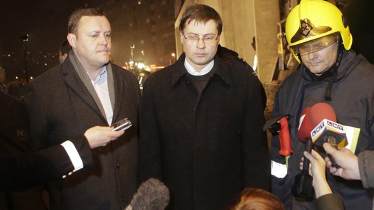 El primer ministro de Letonia, Valdis Dombrovskis (centro), y el ministro de Interior, Rihards Kozlovskis, visitan el lugar del derrumbe del centro comercial, el pasado 21 de noviembre en Riga.