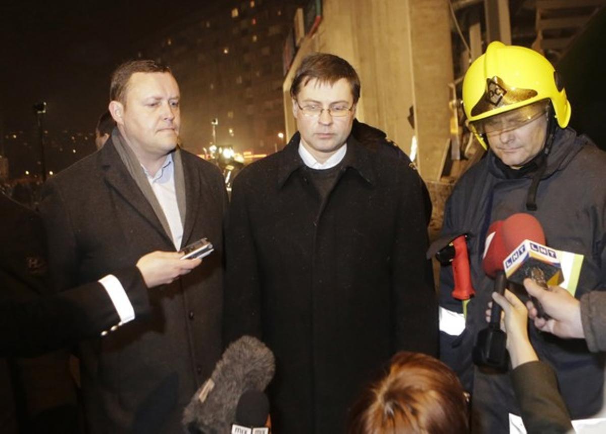 El primer ministre de Letònia, Valdis Dombrovskis (centre), i el ministre d’Interior, Rihards Kozlovskis, visiten el lloc de l’ensorrament del centre comercial, el 21 de novembre a Riga.