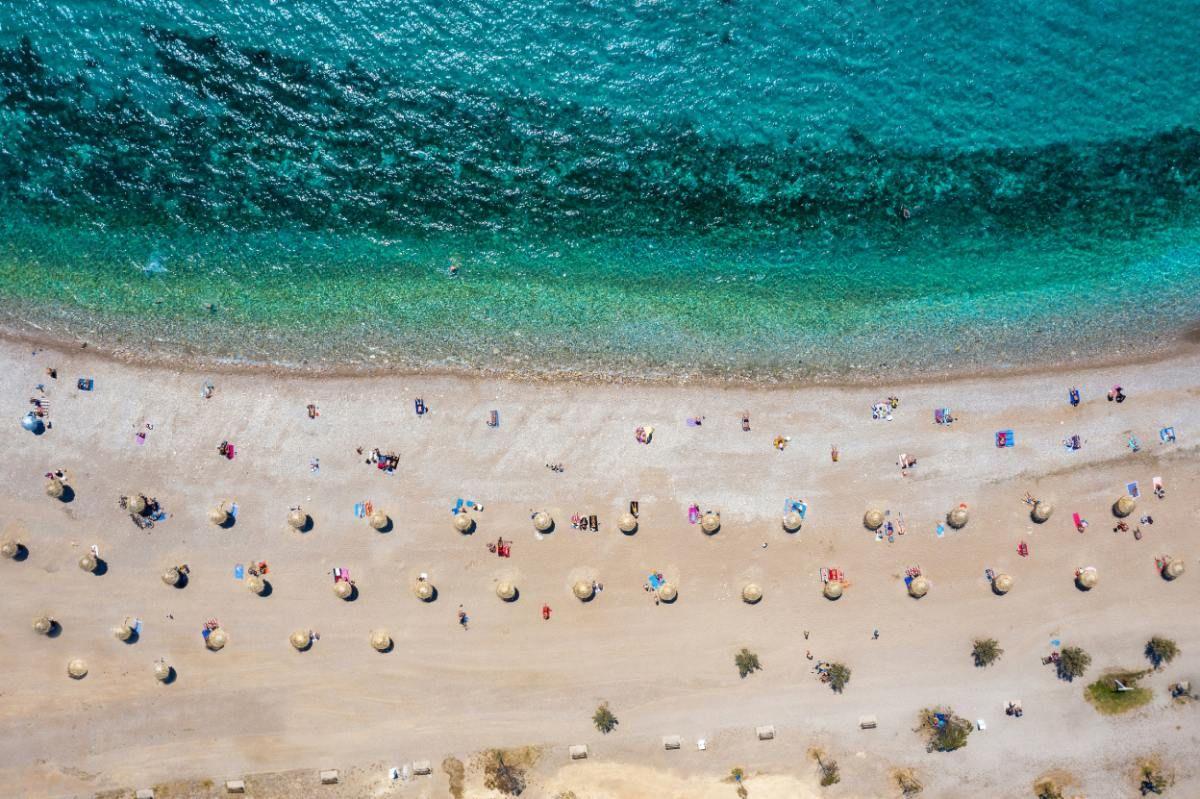 Visitantes separados por distancia social durante el Coronavirus en una playa de Grecia