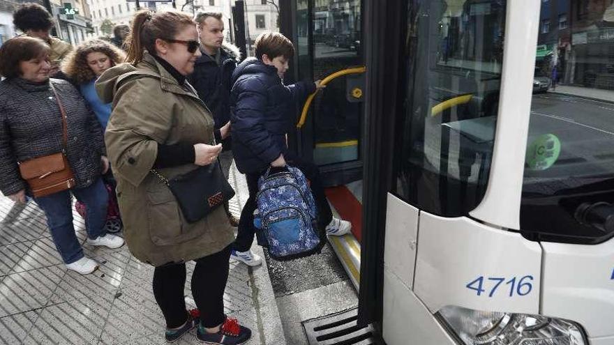 Sandra Berrocal y su hijo Nicolás Huergo, de 10 años, ayer, subiendo a un autobús urbano.