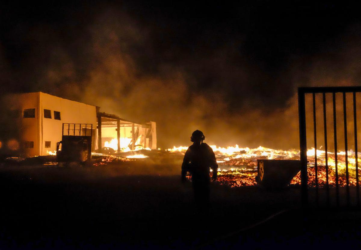 Un espectacular incendio calcina una fábrica de palets en La Marina.