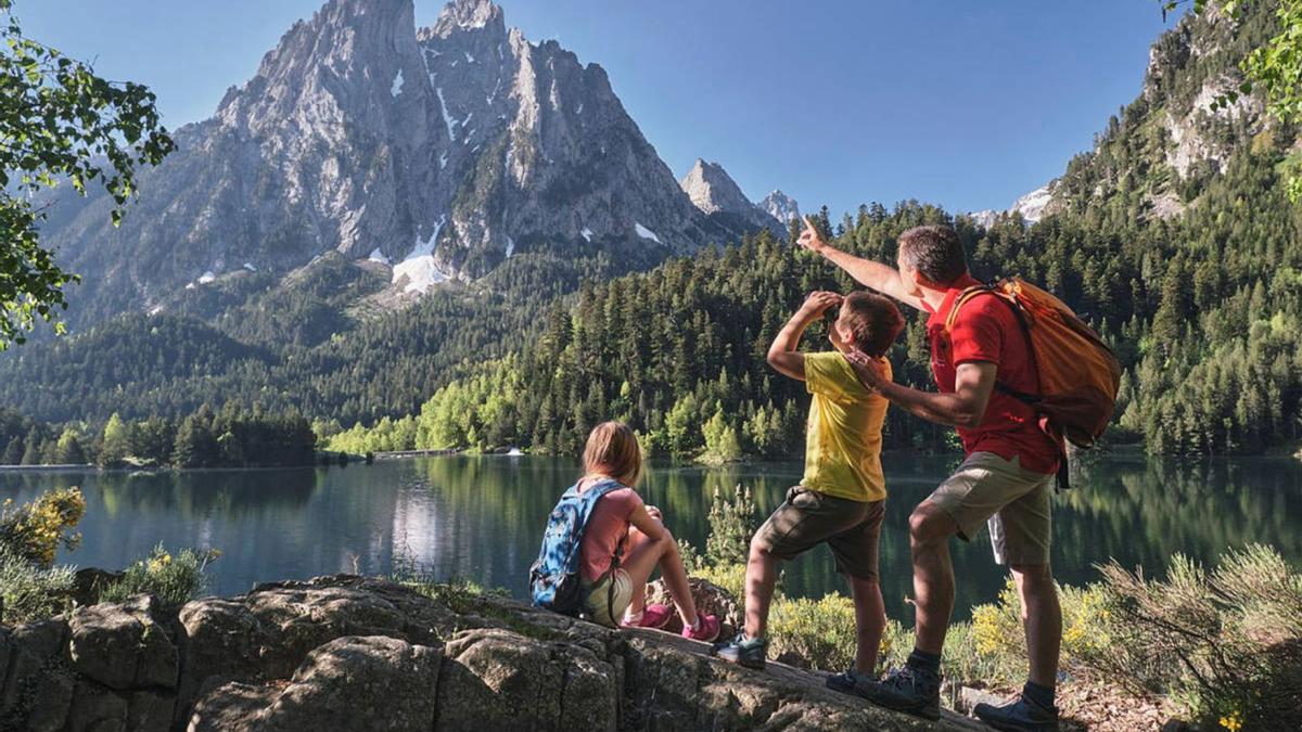 Una família en una ruta de senderisme pel Parc Nacional d’Aigüestortes admirant les agulles dels Encantats  | ORIOL CLAVERA