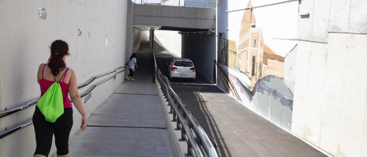 Una mujer y un coche cruzan el paso inferior de las vías del tren inaugurado en 2020 en l’Alcúdia de Crespins.  | PERALES IBORRA