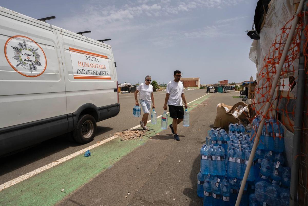 Reparto de agua embotellada de 'València és refugi' en el asentamiento de Fórmula 1.