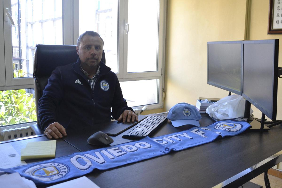 Luis Álvarez en su despacho con una bufanda y una gorra del club.
