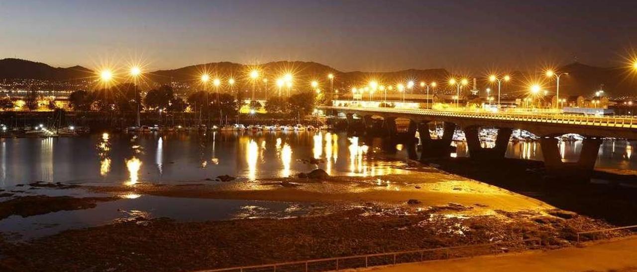 Al fondo, las torres de luz iluminan el ámbito de Zona Franca en Bouzas. // R. Grobas