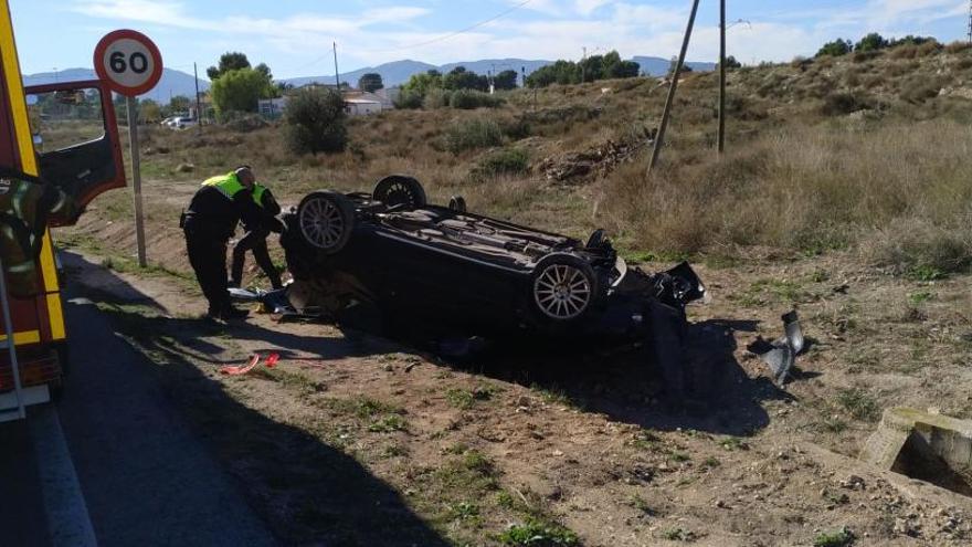 Los agentes inspeccionando el coche siniestrado