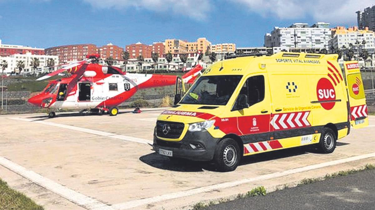 El helicóptero del GES, junto a la ambulancia del SUC  con el pescador rescatado, en la helisuperficie del Hospital Negrín.