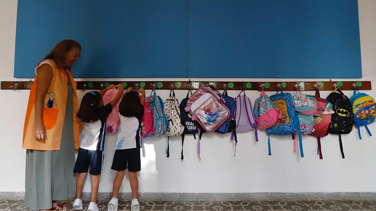 Unas alumnas cuelgan sus mochilas antes de entrar en clase.