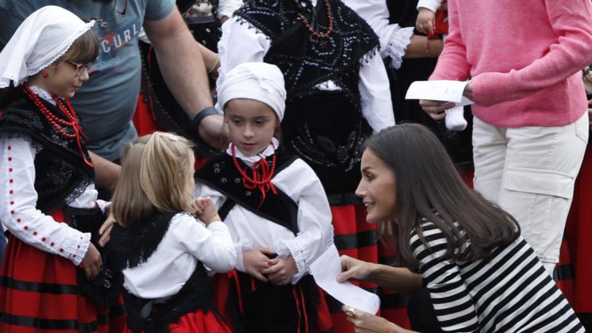 Letizia charla con un grupo de niñas vestidas con el traje tradicional asturiano. | L. Murias